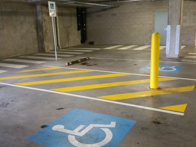 Accessible Car Parking in a basement car park, with two spaces and a central shared area between each space